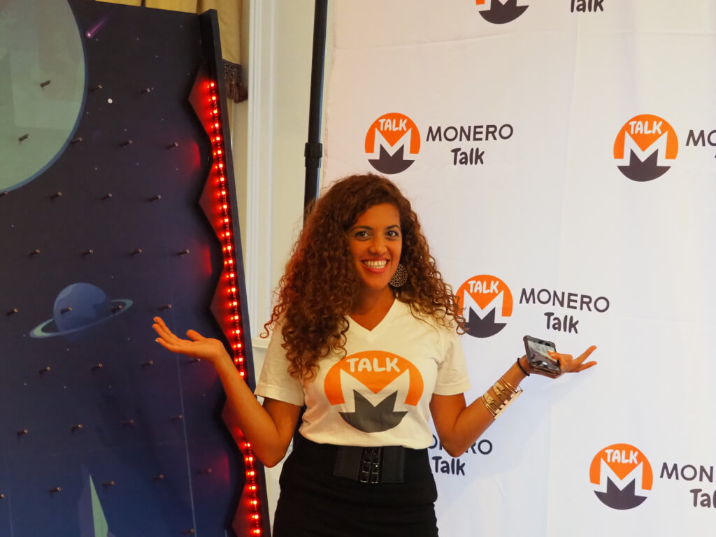 Bild einer Frau, die vor einem Monero Talk-Banner steht